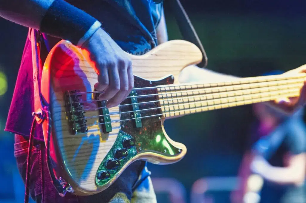 Bajista en concierto después de saber cómo grabar y producir una línea de bajo potente con groove